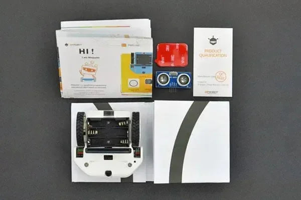 Kit robot educativo Maqueen Lite bianco, sensori e manuali su sfondo grigio