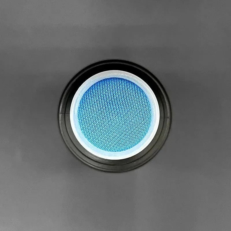 Vista dall'alto di un flacone spray adesivo per stampa 3D, tappo blu su sfondo grigio.