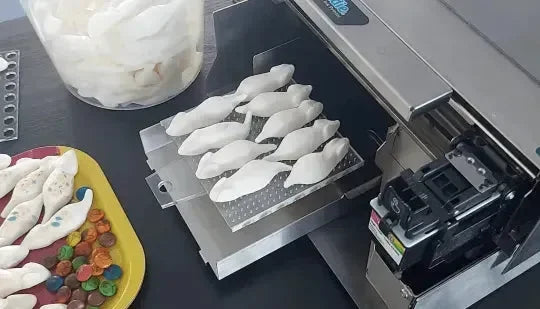 Vassoio manuale con stampante 3D che realizza oggetti bianchi a forma di colomba